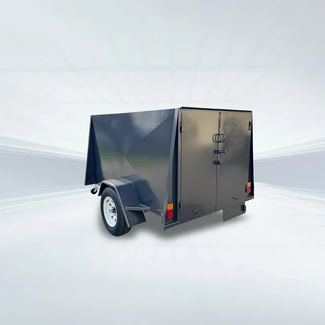 Studio three-quarter view of black 7x4 enclosed trailer with 750kg GVM, 4ft internal height, and rear barn doors on white background.