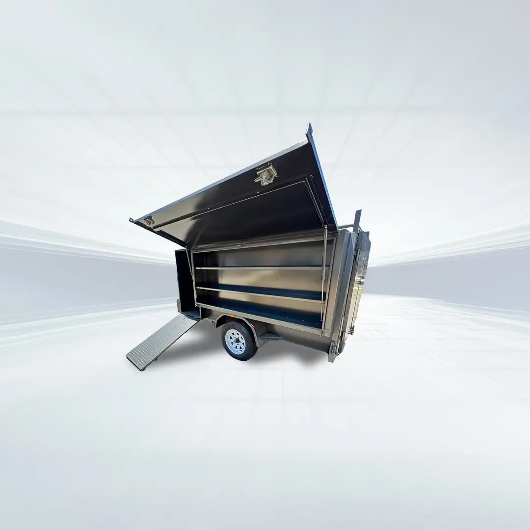Studio angled view of black 7x5 lawn mowing trailer with barn doors open and ramp deployed on white background.